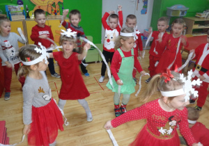 Dzieci tańczą w kole z paskami bibuły